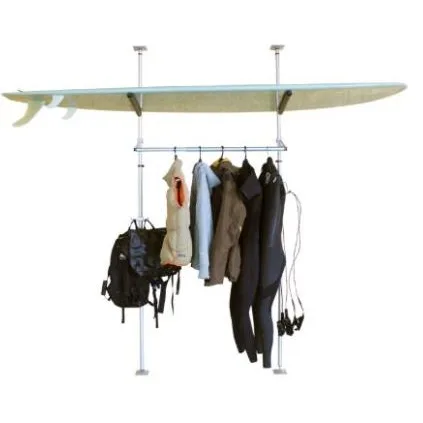 Two poles holding a surfboard on top with wetsuits and a backpack hanging on a rail below